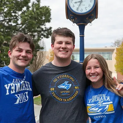 students pose for a photo in front of a decorative clock